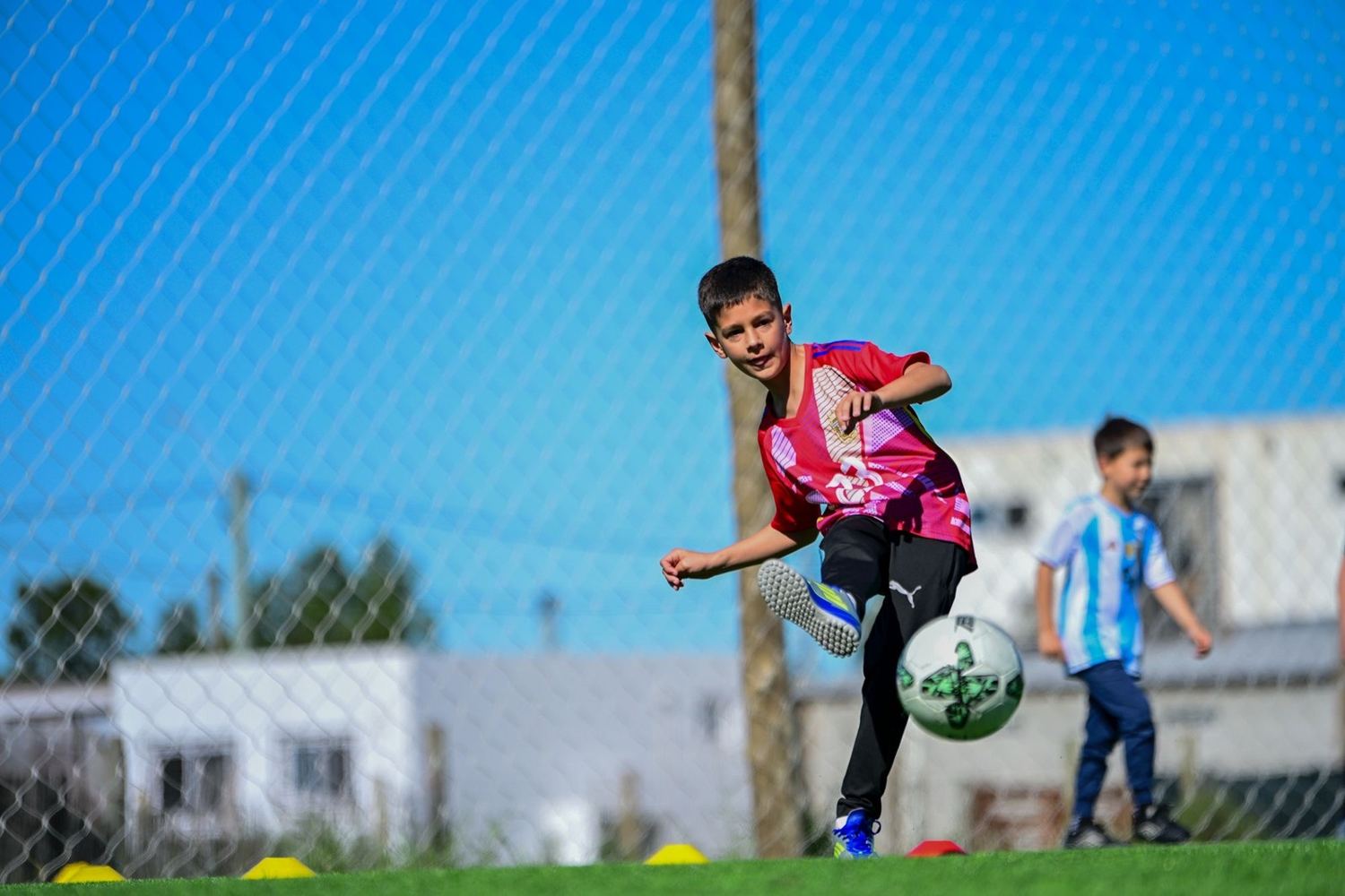 Niño de la academia pateando la pelota